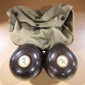 Two Pickering Deluxe lawn bowls and a military canvas pouch