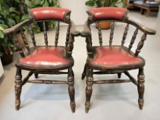 A pair of oxblood studded leather upholstered captain's style armchairs, width 60 cm.