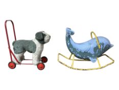 A vintage child's pushalong dog cart and a ride on dolphin toy.