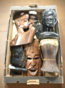 A group of African carved wooden masks, busts, a hide covered drum, etc.