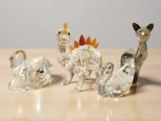 A Swarovski crystal dinosaur, a cat and two swans, tallest 6.5 cm.