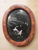 A Japanese lacquered panel inlaid with mother of pearl depicting figure in a rickshaw,