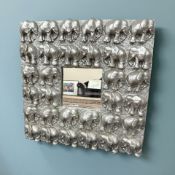 A wooden mirrored carved in relief depicting elephants, 77 cm x 77 cm.