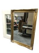 A reproduction gilt over mantel mirror, 107 cm x 77 cm, together with a cream leather framed mirror.