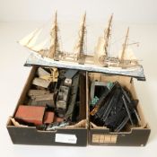 A scale model sailing ship, tin plate rolling stock, track, other tin plate models.
