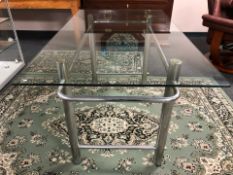 A contemporary rectangular glass topped table on metal support, 140 cm x 80 cm x 72 cm.