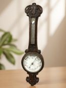 A heavily carved aneroid barometer, height 84 cm.