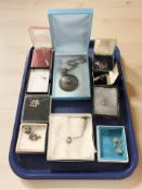 A group of silver pendants including amber and mother of pearl examples, a filigree disk pendant,