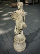 A weathered concrete garden figure of a lady holding a wicker basket, height 95 cm.