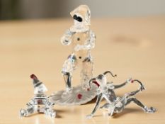 A Swarovski crystal figure of a kneeling harlequin and two further smaller figures, tallest 13 cm.