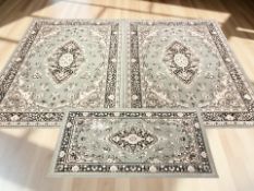 A pair of machine made Persian-style rugs on green ground, each 226 cm x 161 cm,