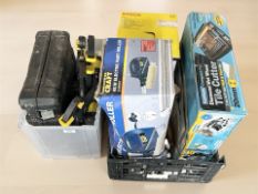 A group of boxed tools including a tile cutter, electric paint roller, Bosch wallpaper stripper,