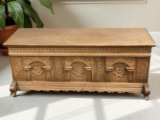 A 20th century heavily carved oak blanket chest, 124 cm x 48 cm x 48 cm.