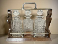 A Victorian oak and silver-plate three bottle Tantalus,