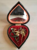 A heart-shaped jewellery box containing a yellow metal swivel pendant and crucifix on chain,