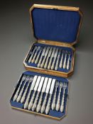 A burr walnut canteen of an ornate twelve place service of cutlery.