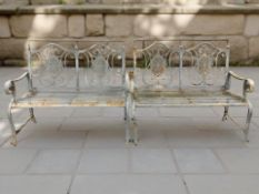 A pair of painted wrought metal garden benches, each 123 cm wide.