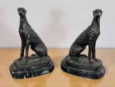 A pair of reproduction bronze figures of seated greyhounds on black marble plinths, height 19 cm.