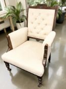 A Victorian salon armchair in buttoned cream upholstery,