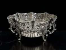 A Victorian silver bowl, finely embossed with grotesque masks and other motifs, on scroll feet,