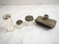 Three antique silver-mounted crystal dressing table jars, and a desk blotter.