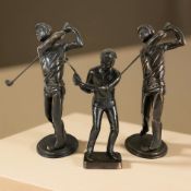 Three reproduction patinated metal figures of golfers, tallest 27 cm.