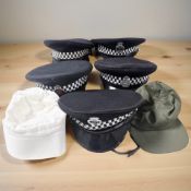 A group of police caps and other hats.