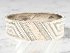 A late Victorian silver bangle with engraved decoration, inner diameter 5.