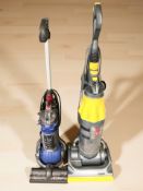 Two upright Dyson vacuum cleaners