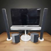 A Bang & Olufsen television with a pair of tower speakers, and a further pair of oval speakers,