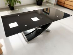 A contemporary polished steel and painted metal based glass topped extending table,
