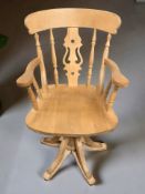 A pine spindle back swivel armchair