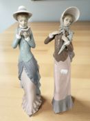 A pair of Lladro figures of ladies, one carrying a parasol and the other reading a book,