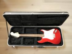 A Squier by Fender Strat electric guitar, in a hard shell guitar case.