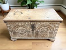 A continental heavily carved oak coffer on bun feet, width 86 cm.
