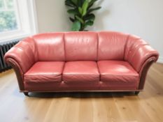 A contemporary wooden framed Burgundy leather three seater settee,