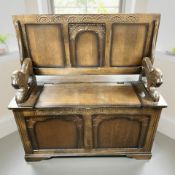 A reproduction carved oak folding monk's bench, 96 cm wide.