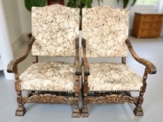 A pair of continental heavily carved beech armchairs on lion paw feet,