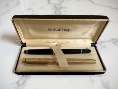 A gold plated Sheaffer fountain pen with 14ct gold nib, together with a Mont Blanc ballpoint pen.
