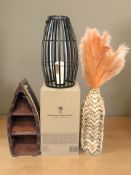 A wicker vase, a small shelf in the form of a rowing boat and a contemporary candle lantern,