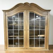 A reproduction oak wall cabinet with leaded glass doors, 88 cm x 26 cm x 90 cm.