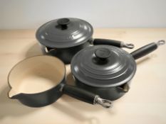 Three Le Creuset enameled cast iron saucepans, two with lids, the largest 20 cm diameter.
