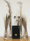 A group of dried flowers in contemporary vases and a large circular mirror, diameter 110 cm.