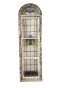 A stained and leaded glass pine-framed domed window, circa 1930's,