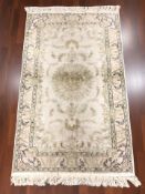 A Kashmir silk piled rug, 168 cm x 93 cm.