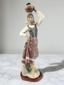 A large Lladro matt glaze figure, Returning from the Well, number 2342, on wooden plinth,