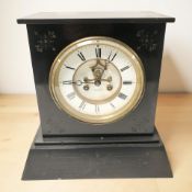 A Victorian black slate eight day mantel clock with visible escapement,