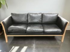 A contemporary Danish wooden framed black leather three seater settee,