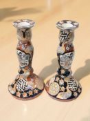 A pair of 20th century Japanese Imari earthen ware candlesticks,