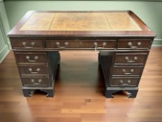 A reproduction mahogany twin pedestal nine drawer writing desk with leather inset top,